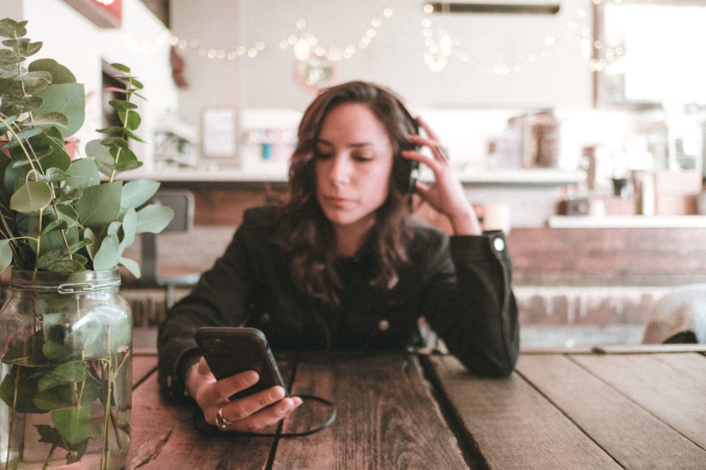 Woman Using AudioFetch App in Restaurant